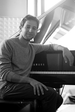 Foto in bianco e nero con il musicista Giovanni Nesi vicino al pianoforte