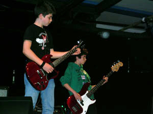 Foto di due ragazzi sul palco che suonano la chitarra