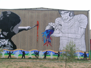 murales intero di un bambno che dipinge con un pennello e un uomo che versa un barattolo di vernice colorata