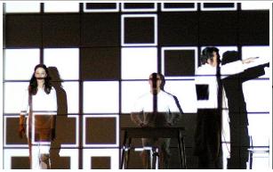 tre attori sul palco con proiezioni sul corpo