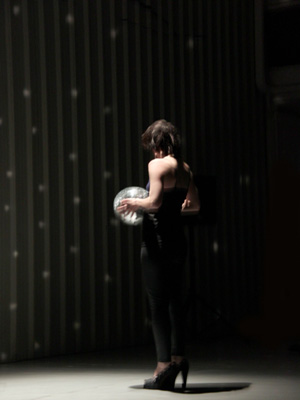 Donna con palla di vetro in mano di fronte a muro 