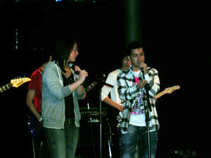 Foto del gruppo sul palco che si esibisce cantando e suonando