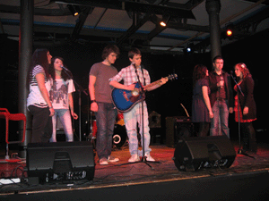 Foto ragazzi del laboratorio sul palco che si esibiscono in tre gruppi