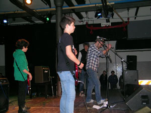Foto del gruppo sul palco che si esibisce cantando e suonando