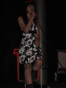 Foto di ragazza del laboratorio su sgabello sul palco durante un'esibizione