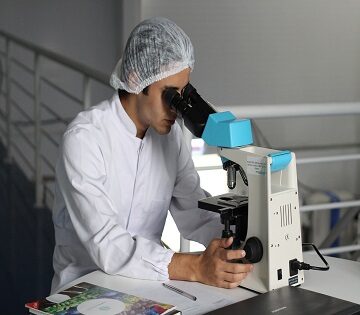 Scienziato che usa un microscopio
