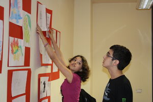 Due ragazzi del laboratorio di fumetto allestiscono la mostra con i disegni
