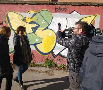  Foto di Hermon Tesfamicael con la giornalista e il cameraman durante l'intervista a Officina Giovani