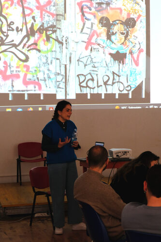  Foto di Alice Pasquini in piedi durante il workshop che spiega ai partecipanti