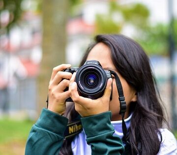 Giovane fotografa con macchina fotografica davanti al viso