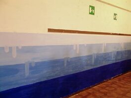Foto di murales a colori raffiguante mare stilizzato su parete di edificio scolastico