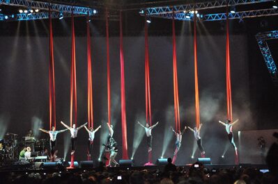 Foto di artisti-acrobati sul palco attaccati ai tessuti aerei durante uno spettacolo